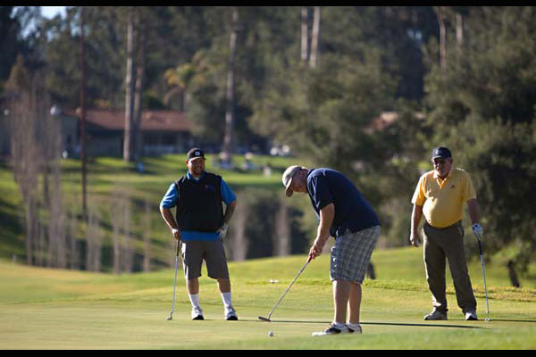 golfers putting on the green