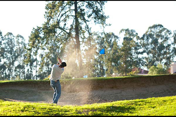 golfer hitting out of the bunker
